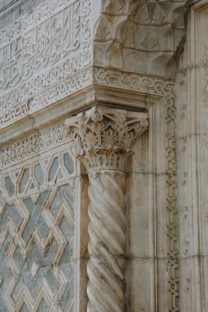Close-up of ornate marble architecture featuring intricate carvings and Islamic geometric patterns.